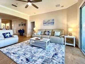 A living room with a sofa, coffee table, and a rug. - Seascape 3BR Condo w/ Hammock Beach Resort Access (Palm Coast)