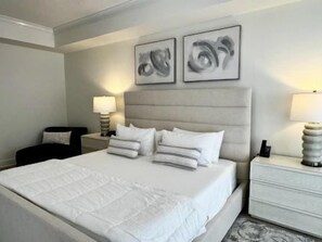 A hotel room with a large bed, two bedside tables, and two wall-mounted lamps. - Modern 3BR Condo w/ Hammock Beach Resort Access (Palm Coast)