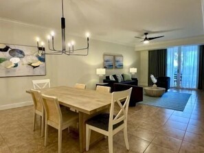 A dining area with a wooden table and chairs, a chandelier, and a ceiling fan. - Intracoastal-View 2BR Condo | Pool & Resort Access (Palm Coast)