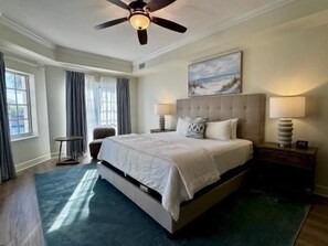 A bedroom with a large bed, a ceiling fan, a nightstand, and a chair. - Waterway-View 3BR Condo w/ Marina + Resort Access (Palm Coast)