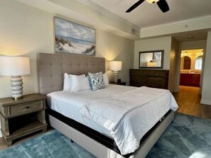 Una camera da letto con un letto, comodini, una cassettiera e una ventola a soffitto.
