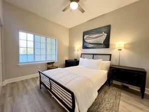 A bedroom with a bed, bedside tables, a window, and a ceiling fan. - 2BR Waterview Condo w/ Hammock Beach Resort Access (Palm Coast)