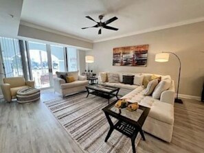 A modern living room with a sofa set, coffee table, and floor lamp. - 2BR Waterview Condo w/ Hammock Beach Resort Access (Palm Coast)