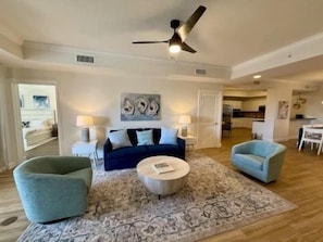 A living room with a blue sofa, two armchairs, a coffee table, and a patterned rug. - Bright 3BR Condo w/ Hammock Beach Resort Access (Palm Coast)