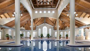 Une piscine intérieure dotée d’un haut plafond et de grandes fenêtres.