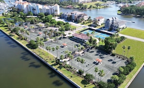 Ein Luftbild eines Hotels mit einem Hafen, Tennisplätzen und einem Schwimmbad.