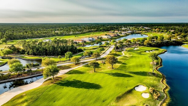 Golfkenttä, jossa on hiekkabunkkereita, vesiesteitä ja klubitalo.