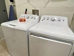 A laundry area with two white front-loading washing machines. - Waterway-View 2BR Condo w/ Pool & Resort Access (Palm Coast)
