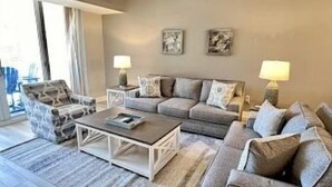A living room with a sofa set, a coffee table, and two lamps. - Pool-View 2BR Condo w/ Balcony + Resort Access (Palm Coast)