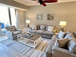 A living room with a sofa set, a coffee table, and two lamps. - Pool-View 2BR Condo w/ Balcony + Resort Access (Palm Coast)
