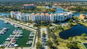 Ein großes Hotel mit mehreren Gebäuden, einer Marina mit Booten und einem Fluss.