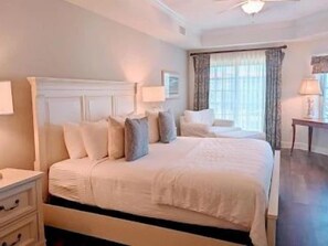 A neatly made bed with pillows and a bedside table with a lamp. - Classic 2BR Condo w/ Hammock Beach Resort Access (Palm Coast)