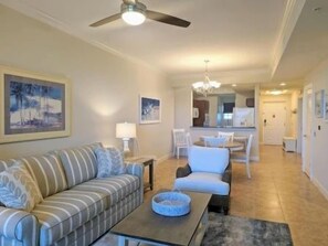 A living room with a sofa, armchair, coffee table, and a ceiling fan. - Classic 2BR Condo w/ Hammock Beach Resort Access (Palm Coast)