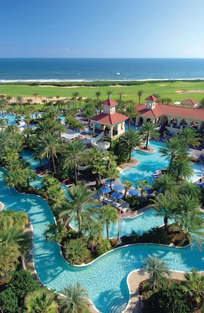 A resort with multiple swimming pools, palm trees, and a view of the ocean. - Classic 2BR Condo w/ Hammock Beach Resort Access (Palm Coast)