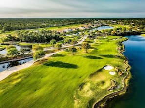 A golf course with bunkers, water hazards, and a clubhouse. - Waterfront 2BR Condo | Hammock Beach Resort Access (Palm Coast)