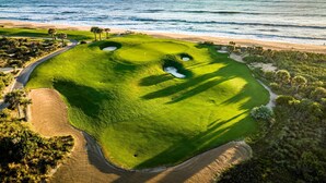 Ein Golfplatz mit Sandstrand und Meerblick.