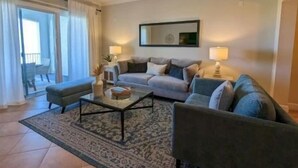 Ein Wohnzimmer mit einer Sofagarnitur, einem Couchtisch und einem Deckenventilator.