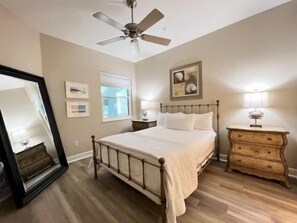 A bedroom with a bed, dresser, mirror, ceiling fan, and framed artwork on the wall. - Oceanfront 3BR Condo | Hammock Beach Resort Access (Palm Coast)