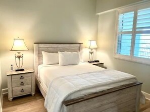Ein Schlafzimmer mit Bett, Nachttischen und Lampen.