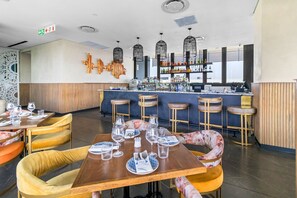 Ein Restaurant mit Barbereich, Holzmöbeln und modernem Interieur.