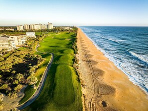 A coastal golf course with a beachfront view, surrounded by residential buildings. - Lake-View 5BR Home w/ Private Pool + Resort Access (Palm Coast)