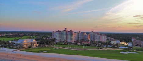 Resort tower overlooking a wide sandy beach under a pastel evening sky