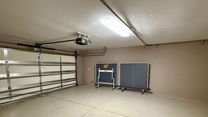 Un garage con una porta metallica, una plafoniera e due armadietti.