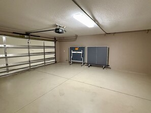 Eine Garage mit einer Metalttür, einer Deckenleuchte und zwei Schränken.