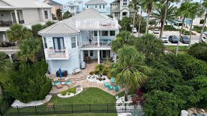 A multi-story house with a balcony, a patio with outdoor furniture, and a well-maintained garden. - Pet-Friendly Home w/ Hammock Beach Resort Access (Palm Coast)