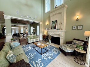A spacious living room with a fireplace, a dining area, and a view of the kitchen. - Spacious 3BR Home w/ Rooftop Deck + Resort Access (Palm Coast)