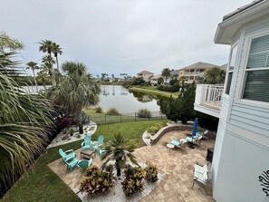 A residential area with a lake, a patio with outdoor furniture, and a pool. - Spacious 3BR Home w/ Rooftop Deck + Resort Access (Palm Coast)