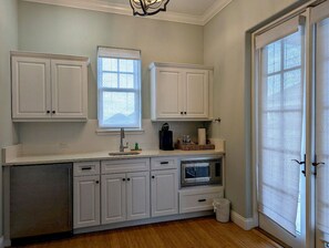 A kitchen with white cabinets, a window, a sink, and an oven. - Oceanview 5BR Home w/ Hammock Beach Resort Access (Palm Coast)