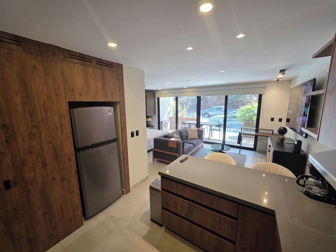 Una cocina moderna con refrigerador empotrado, armarios de madera y una isla central.