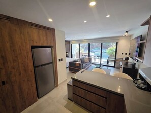 Eine moderne Küche mit Einbaukühlschrank, Holzschränken und einer zentralen Kochinsel.