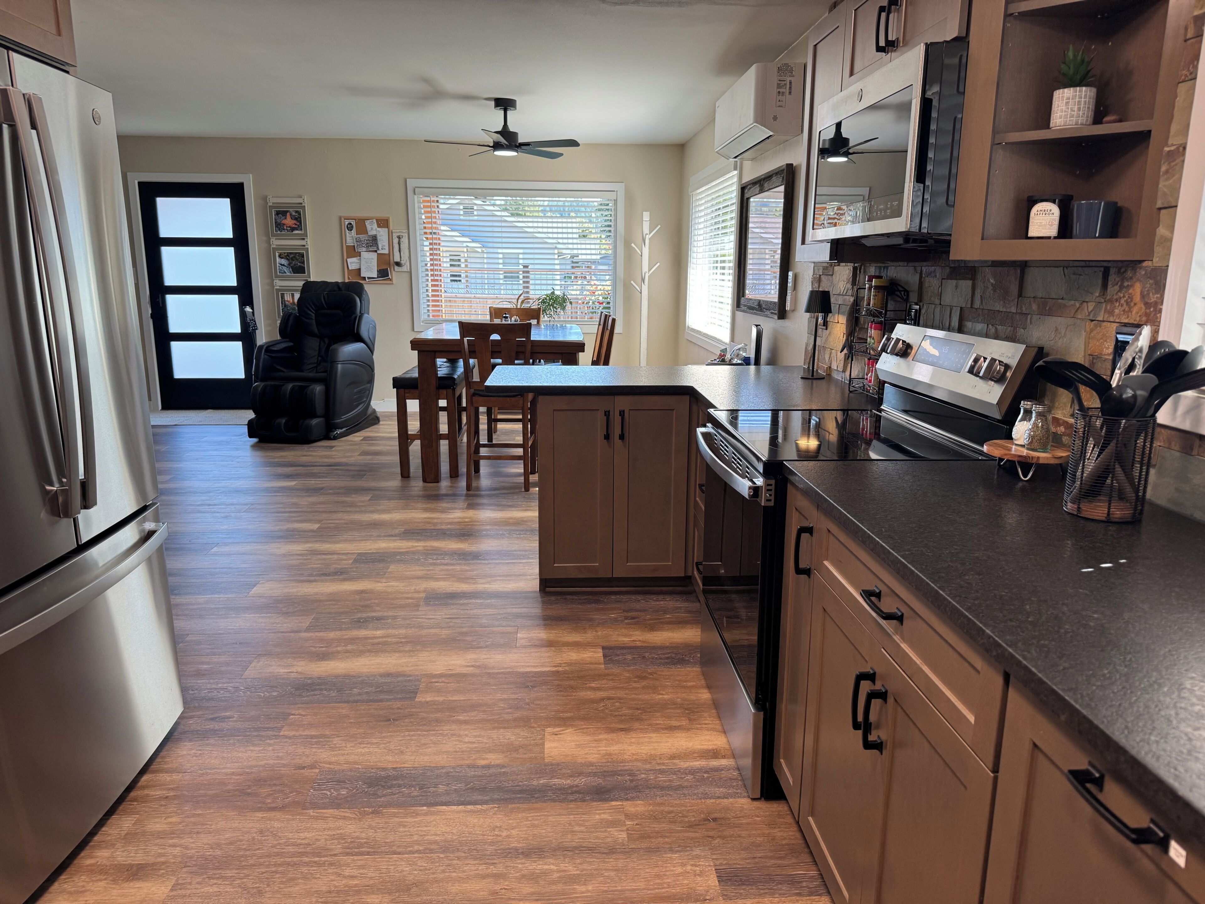 A modern kitchen with wooden cabinets, a built-in dishwasher, and a countertop with a coffee machine.