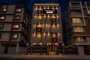 A multi-story building with a prominent sign reading 'TOWNHOUSE' and 'OYO-Serviced'. - Deluxe Skyline Haven (Barasat)