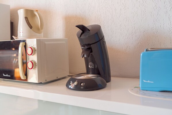 A kitchen counter with a toaster, a coffee maker, and a blue appliance. - T2 climatisé avec grande terrasse – Plage et Port à pied (Saint-Cyprien)