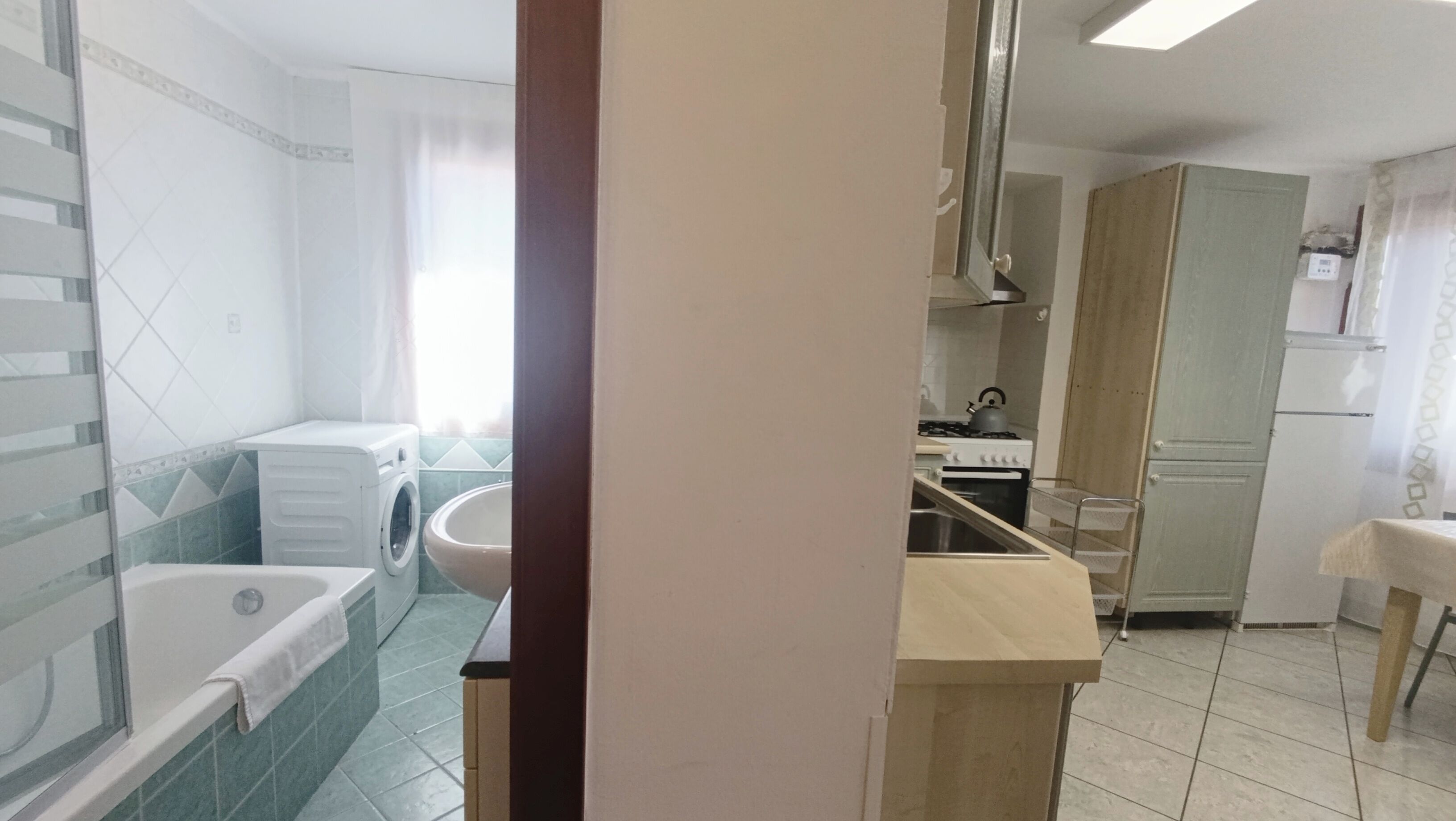 Une salle de bain avec une baignoire, un lave-linge et un lavabo.