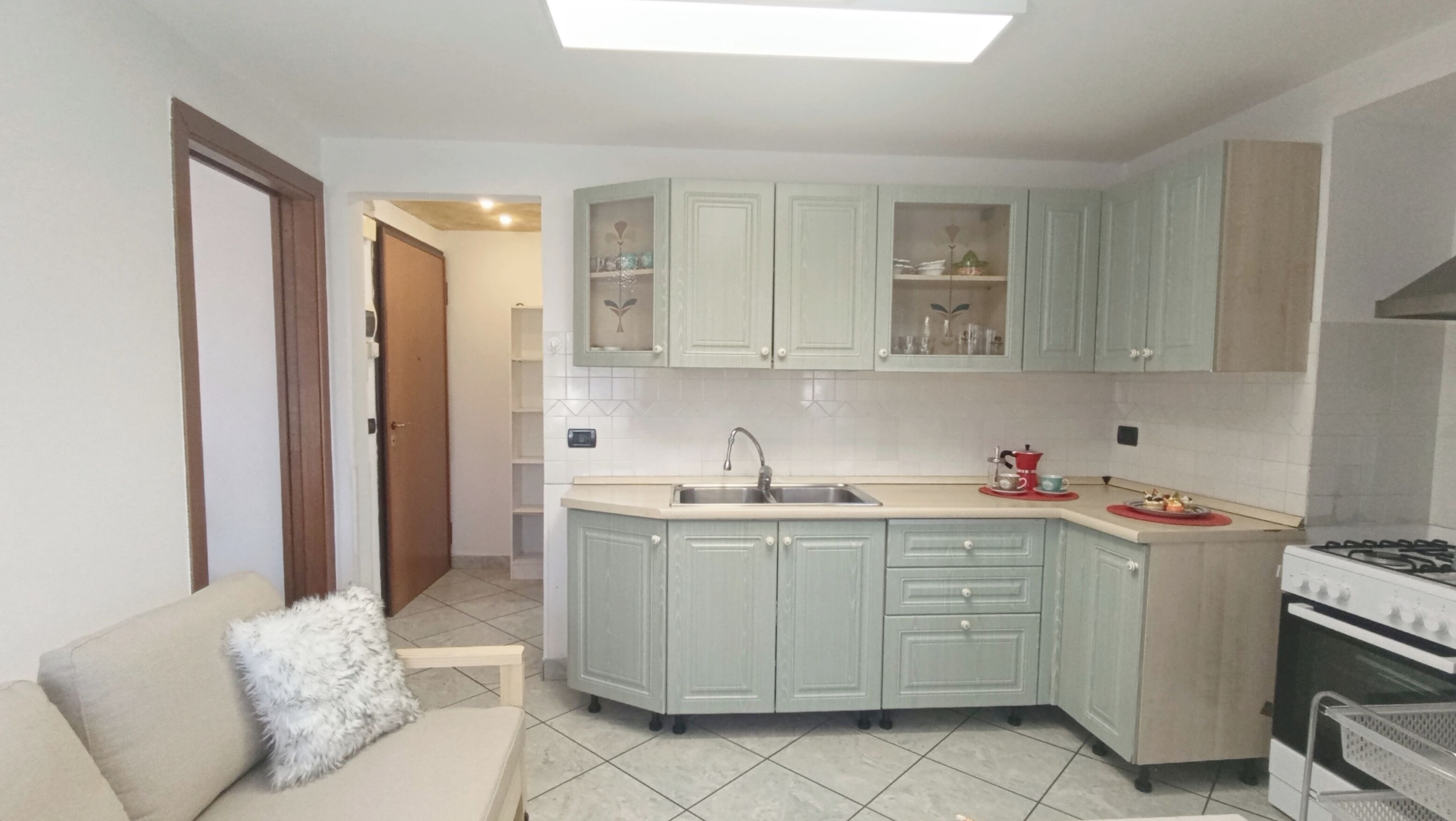 A compact kitchen with a central island, a stove, and a sink.