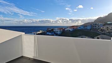 Ein Balkon mit Blick auf eine Küstenstadt und das Meer.