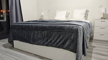 Una camera da letto moderna con un letto, comodini e un tavolino da notte.
