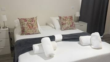 Una camera d'albergo con un letto, due comodini, una lampada e una finestra con tenda.