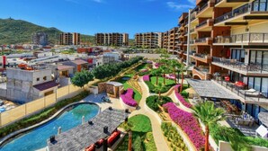 A resort with multiple buildings, a swimming pool, and landscaped gardens. - Quivira Luxury Penthouse | Ocean Views & Resort Amenities (Cabo San Lucas)
