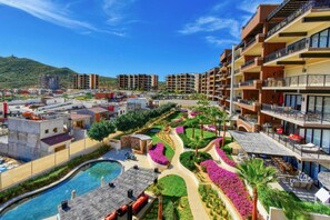 A resort with multiple buildings, a swimming pool, and landscaped gardens. - Quivira Luxury Penthouse | Ocean Views & Resort Amenities (Cabo San Lucas)