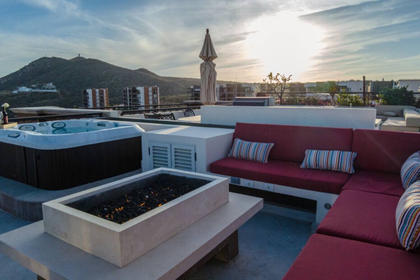 Une terrasse sur le toit avec un jacuzzi, un espace salon et une vue sur une montagne.