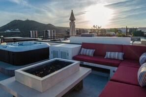A rooftop terrace with a hot tub, seating area, and a view of a mountain. - Quivira Luxury Penthouse | Ocean Views & Resort Amenities (Cabo San Lucas)