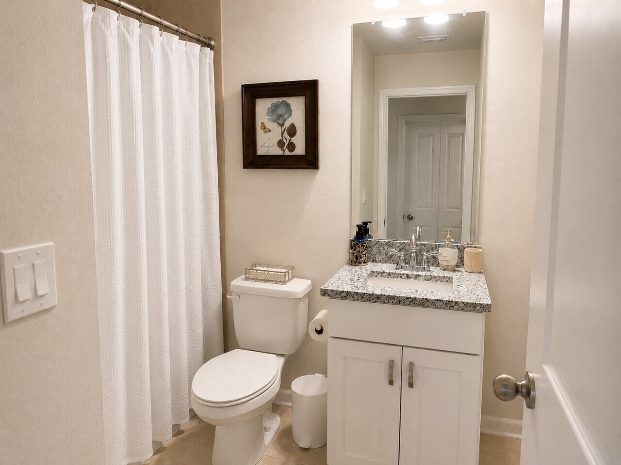 A bathroom with a toilet, sink, and shower curtain.