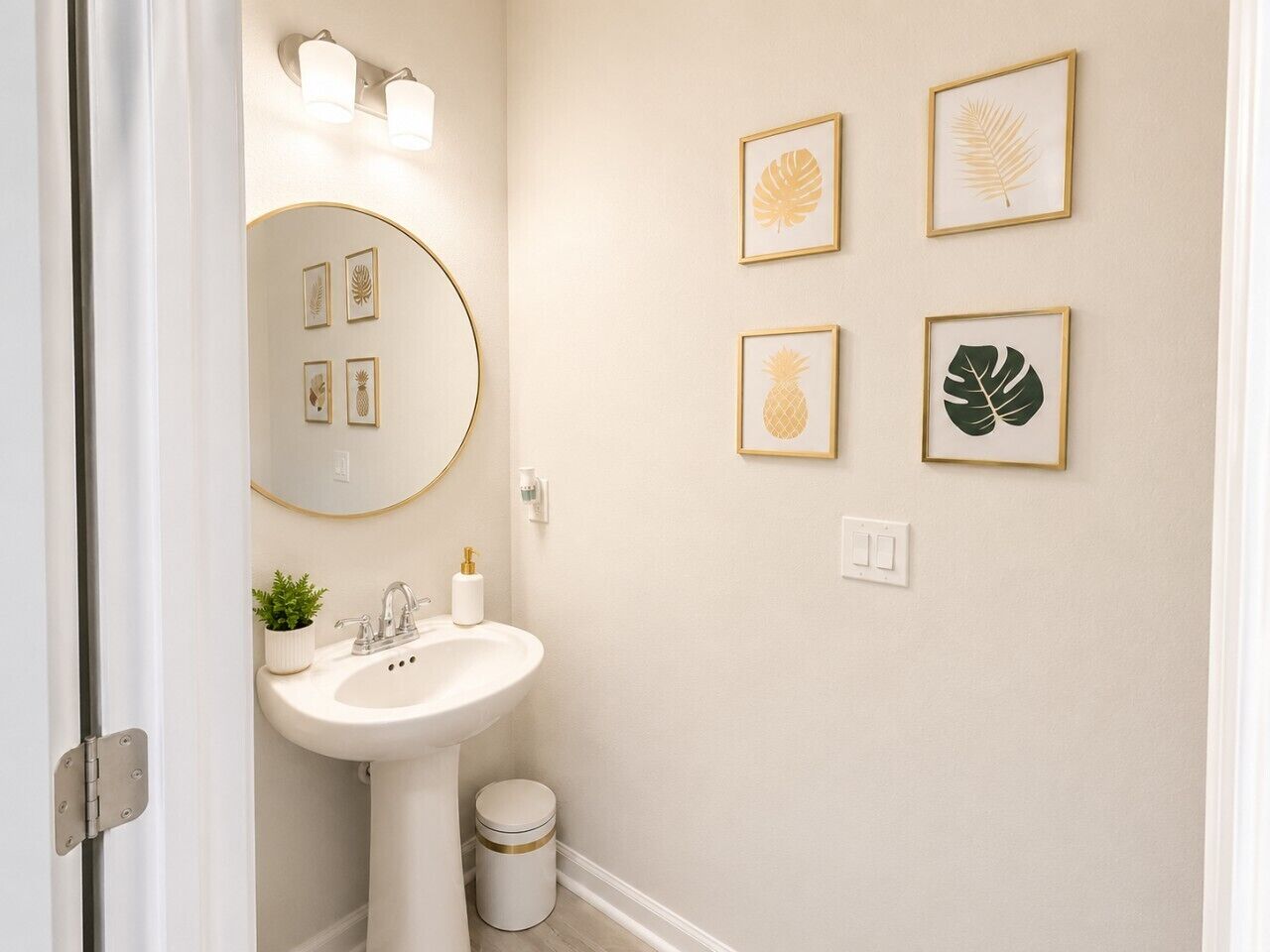 A bathroom with a white sink, a round mirror, and framed botanical prints on the wall.