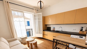 Un appartement moderne comprenant un espace de vie, une cuisine et un balcon.