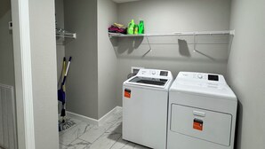 A laundry room with two Whirlpool washers and dryers, a mop, and a mop bucket. -  Peaceful Country Getaway 3BR • 2BA • Fire Pit • Near Outdoor Adventures (Clarkrange)